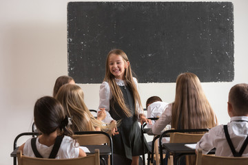 School children in classroom at lesson. The little boys and girls sitting at desks. Back to school, education, classroom, lesson, learn, lifestyle, childhood concept