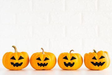 Wall Mural - yellow ghost pumpkin on white brick block background. halloween concept.