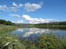 Picturesque Landscape With Green Valley, River, Hills And Blue Sky. White Clouds Are Reflected In The Water Surface