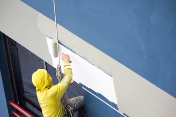 Wall Mural - painters hanging on roll, painting color on building wall. renovation work.