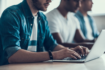 Closeup of Young Man Working on Laptop in Office