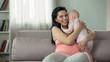 © motortion - Cute pregnant woman kissing and hugging daughter, love and tenderness in family