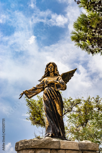 Fotografie, Obraz A bronze statue of an angel in Santa Maria di Leuca