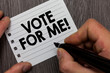 Conceptual hand writing showing Vote For Me. Business photo showcasing Campaining for a government position in the upcoming election Man holding marker notebook page Wooden background