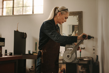 Goldsmith crafting gold on a manual machine