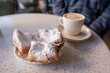 Beignets covered with powdered sugar, served with cafe au lait at the famous Cafe Du Monde in the French Quarter. Shallow focus on the powdered sugar for effect.