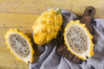 Wall Mural - yellow pitahaya dragon fruit on wooden background