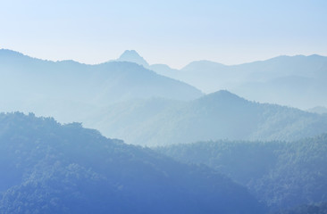 landscape view of sunrise on high angle view over rainforest mountain with white fog in early morning at thailand 