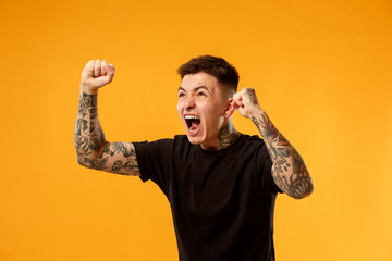 I won. Winning success happy man celebrating being a winner. Dynamic image of caucasian male model on gold studio background. Victory, delight concept. Human facial emotions concept. Trendy colors