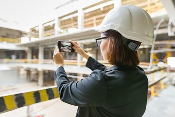 Portrait of mature architect woman at a construction site. Building, development, teamwork and people concept