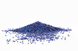 Stack of a blue plastic polymer granules on a white background, copy space