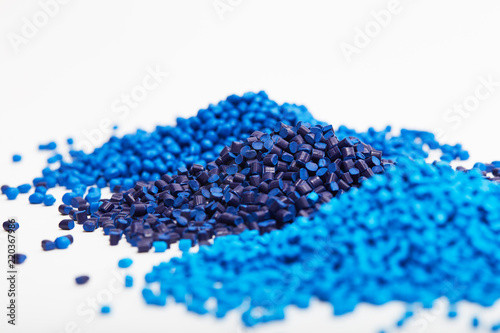 Cuadros en Lienzo Stacks of a blue plastic polymer granules on a white background, copy space