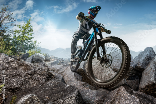 Fotografía Mountain biker on stone trail. Male cyclist rides the rock