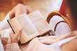 © vitaliymateha - Soft photo of woman in a wicker chair with old book and cup of coffee