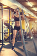 © luckybusiness - Sportswoman doing exercise with rope in gym