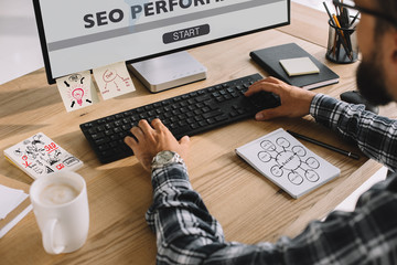 Wall Mural - cropped shot of seo manager in plaid shirt using computer at workplace