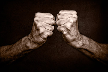 Photo of senior man fists on black background, symbolizing protection and defense, but also attack  and aggressivity