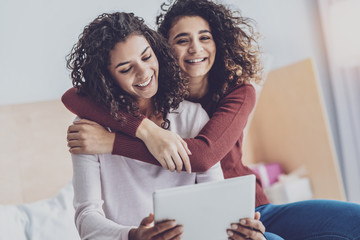 Love in the air. Cheerful females demonstrating their relations and smiling on camera