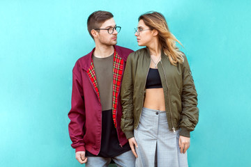 fashion couple standing posing near blue wall