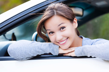 Wall Mural - Happy owner of a new car smiling to you. Pretty girl driver