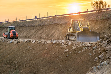 Wall Mural - Excavator moving earth on construction works of a highway