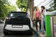 © Wavebreak Media - Couple interacting with each other while charging electric car