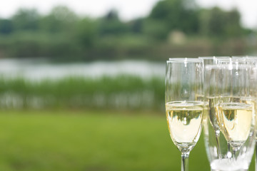 sparkling wine and champagne on a table at a wedding, lake in background