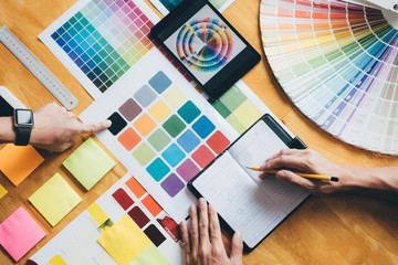 Poster - Young creative team having a meeting in creative office, Architectural drawing with work tools and accessories, Color swatch samples chart for selection coloring
