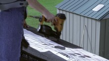 A Man Nails Down A Roofing Tile Trim.