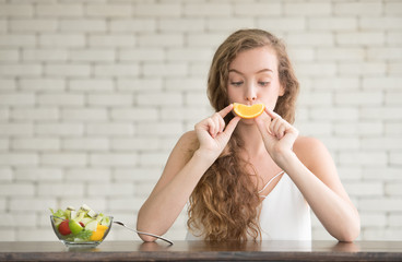 Beautiful young woman in joyful postures with salad bowl on the side