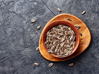 Wall Mural - Sunflower seeds on a black bacground. Top view of snacks.