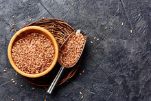 Wild Brown Rice In Wooden Bowl On Black Background With Copy Space. Top View Of Grains.