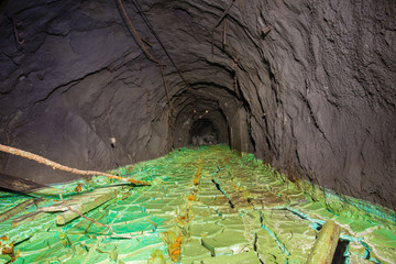 Underground abandoned gold iron ore mine shaft tunnel gallery passage with timbering wooden amazing fantastic green colors acid