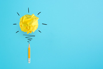 Creative idea. Concept of idea and innovation with paper ball and pencil on blue background.
