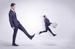 © ra2 studio - Big man in suit kicking out little himself out with simple white wallpaper