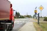 Samochód ciężarowyna na drodze z fotoradarem mierzącym prędkość pojazdów.
