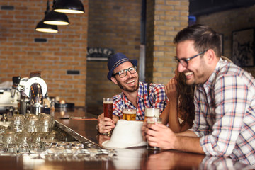 Wall Mural - Happy friends having fun at bar - Young trendy people drinking beer and laughing together