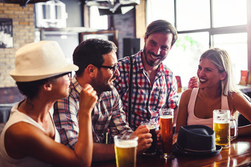 Wall Mural - Happy friends having fun at bar - Young trendy people drinking beer and laughing together