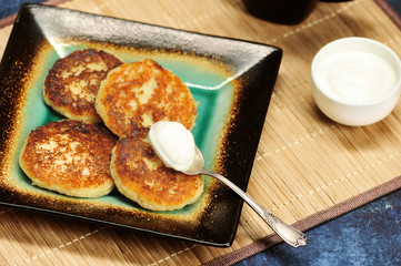 Wall Mural - freshly baked cottage cheese pancakes with sour cream