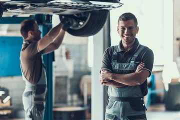 Fototapete - Mechanics Checking Wheel Bearings in Car Workshop