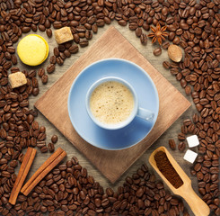 Poster - cup of coffee and beans on wooden background