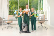 Team of janitors with cleaning supplies in office