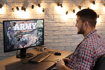 Wall Mural - Young man playing video game at home