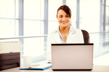 Young attractive business woman using laptop at the office