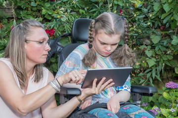 Disability a disabled child learning with help from a special needs carer