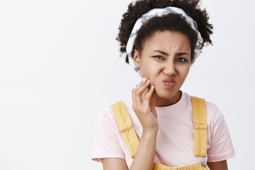 Wall Mural - Gosh not acne again. Displeased unhappy cute female having problems with skincare, touching pimple on cheek and frowning from dislike, staying home, thinking she ugly from bad skin condition