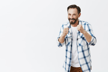 Wall Mural - Come on attack. Portrait of handsome friendly and playful european man with beard, standing in boxer pose and holding raised fists while teaching son how fight, smiling broadly at camera