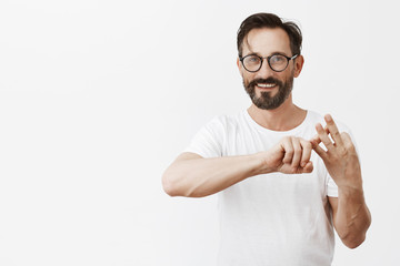 Wall Mural - Three reasons why project worked up. Portrait of charming carefree pleased caucasian man listing up to journalist points, folding fingers while numbering some facts over gray background