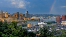 Wide Angle View Of Downtown Cincinnati Ohio And Covenington Kentucky Skylines With Rainbow And Storm Clouds Over Riverfront
