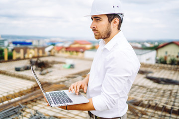 Wall Mural - Construction worker planning with laptop, using technology at construction site